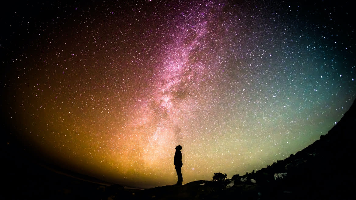 A man standing below the Milky Way.