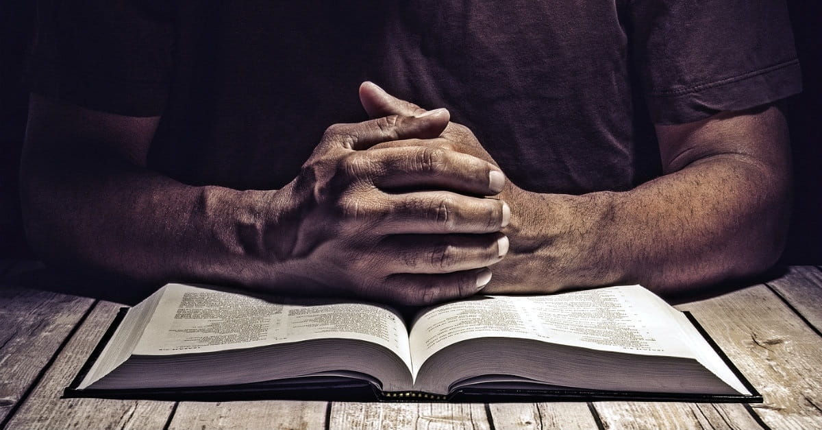 Praying with open Bible.