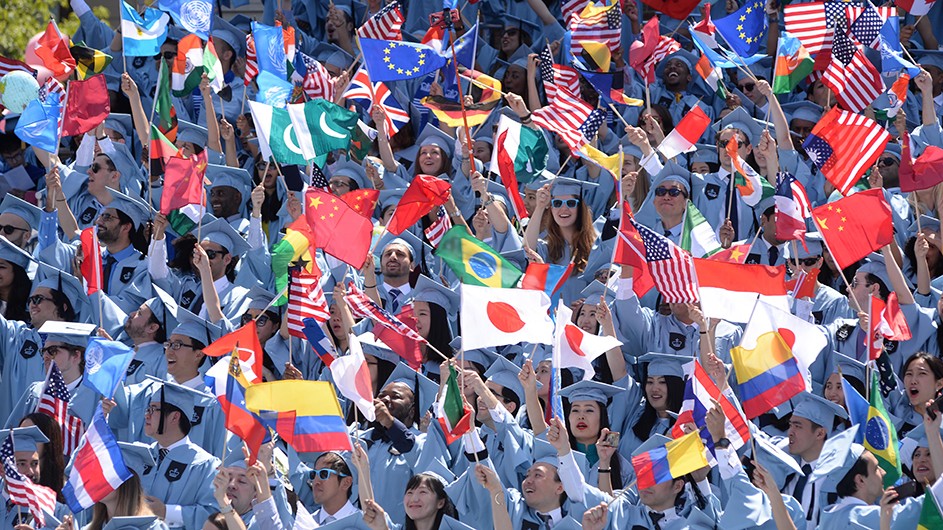 A group of people in blue holding flags

Description automatically generated