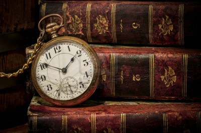 A picture containing an antique pocket watch on a stack of books.

Description automatically generated