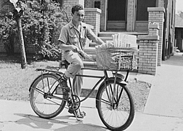 Boy on bicyclew delivering newspapers